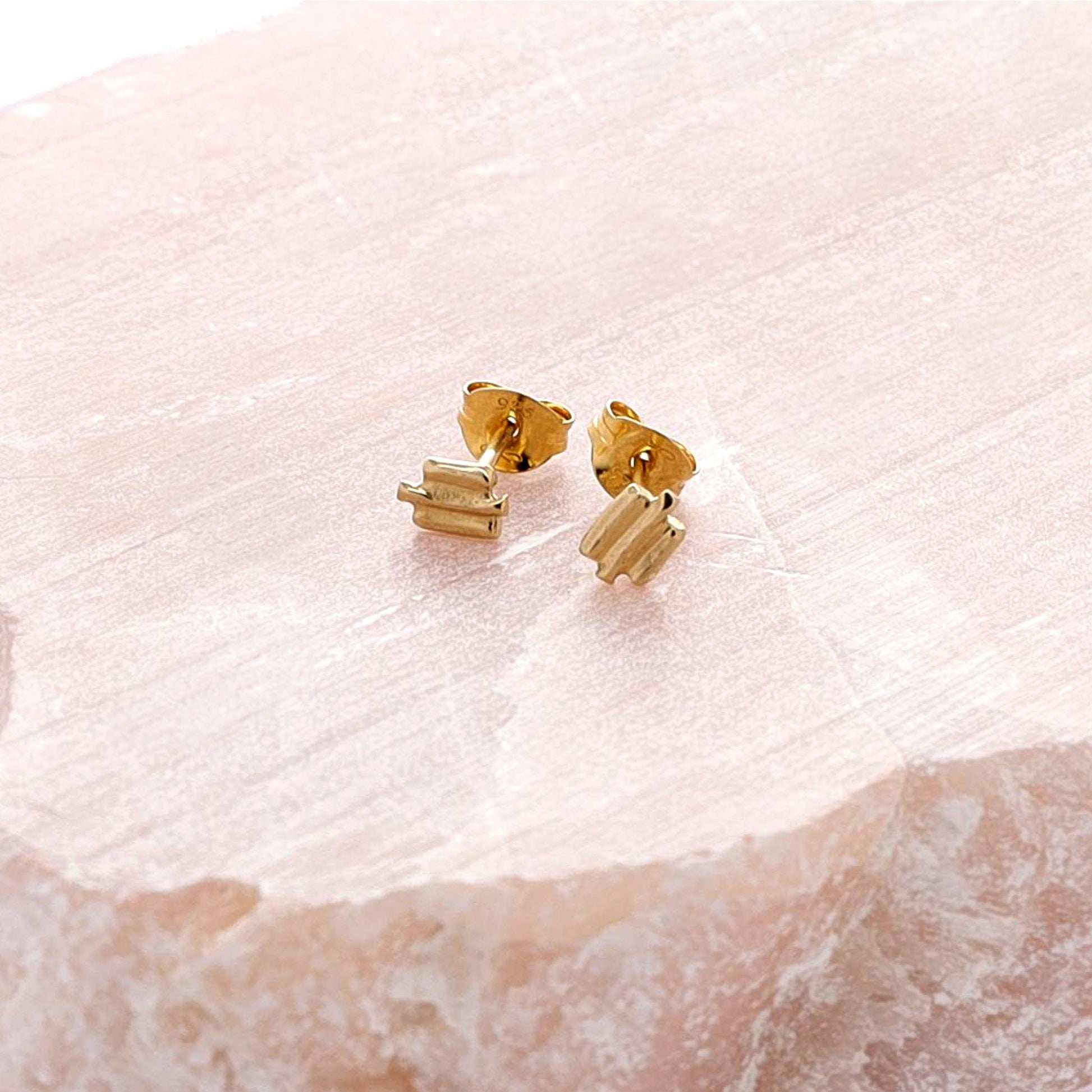 Small gold textured stud earrings.