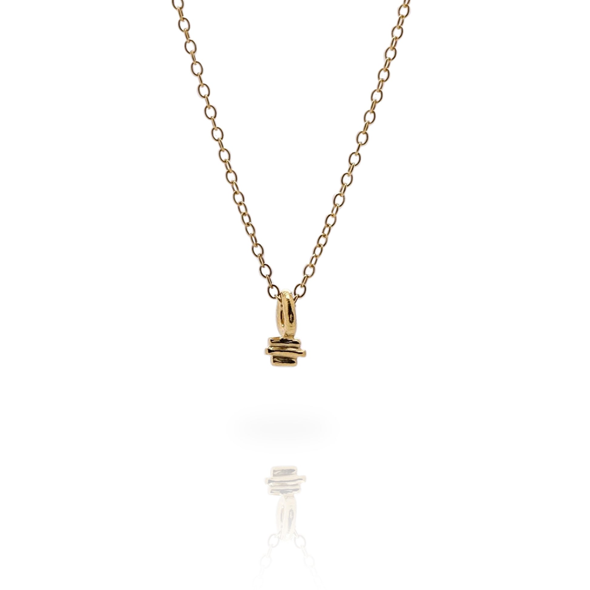 Small gold textured charm on a fine gold chain on a white background.