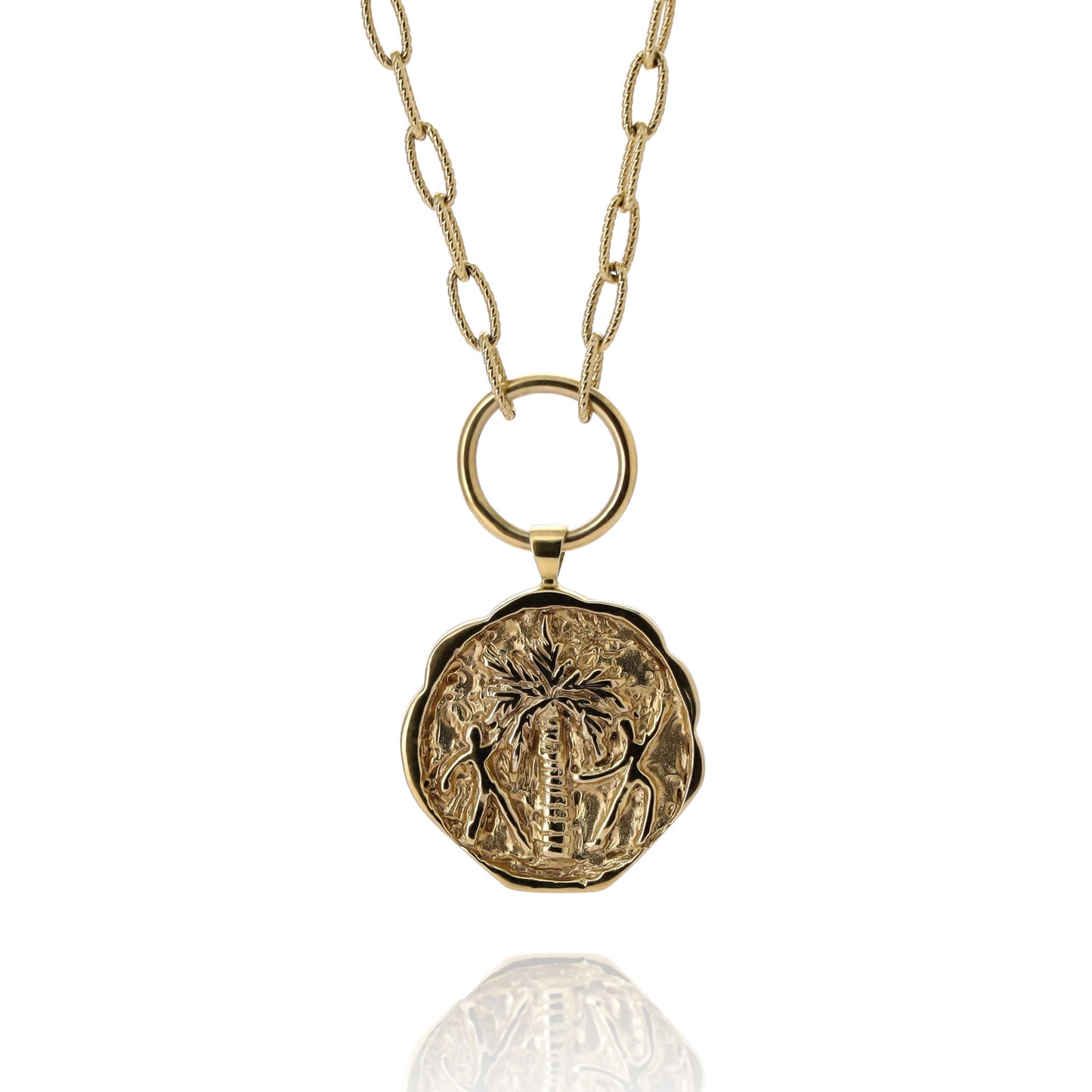 Gold coin pendant necklace engraved with a palm tree and two people dancing around it on a white background.